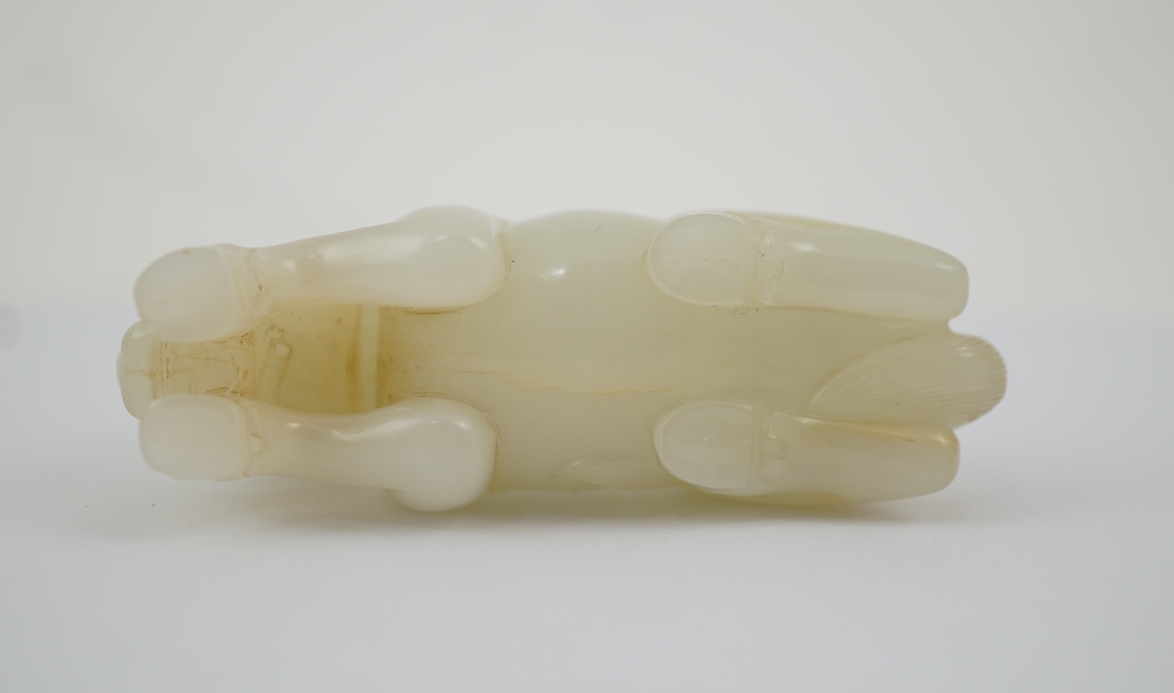 A Chinese white jade figure of a recumbent horse